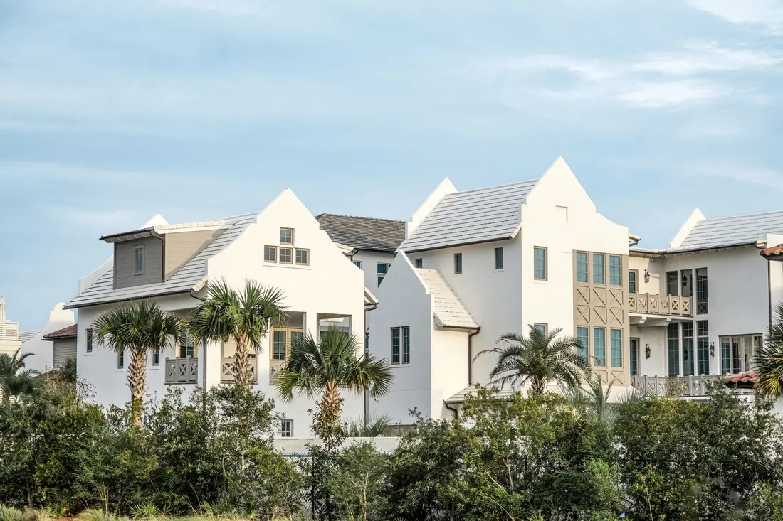 Conjunto de casas blancas entre áreas verdes