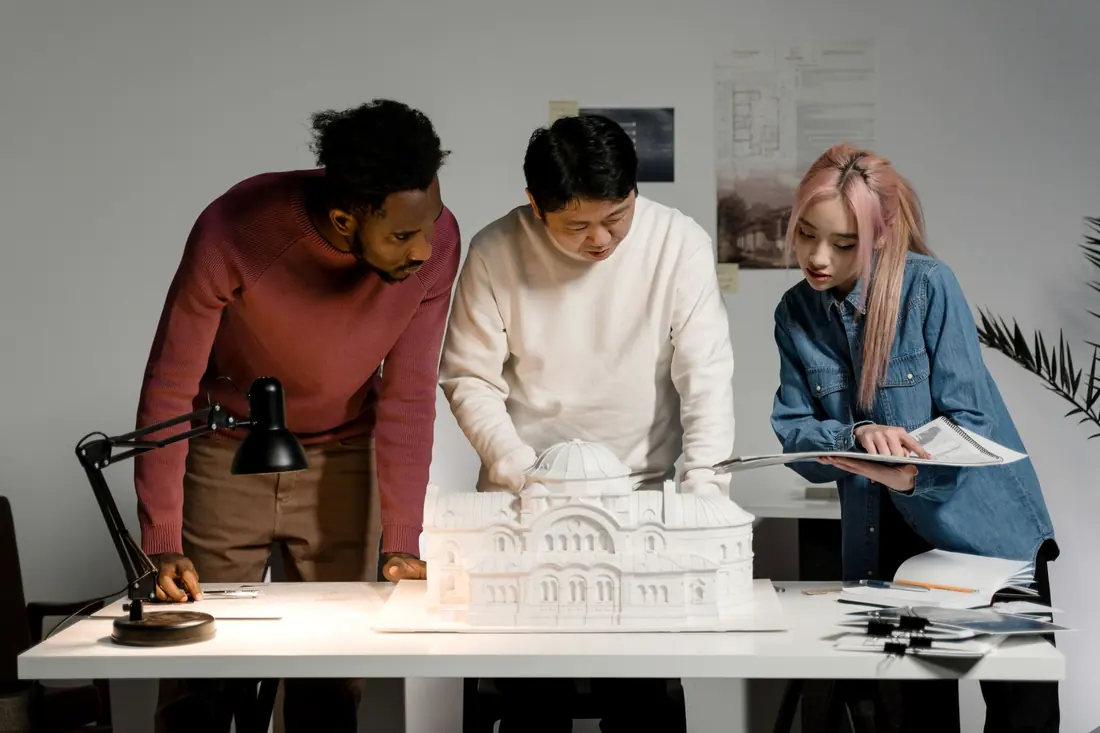 Equipo revisando una maqueta y planos en una mesa de trabajo